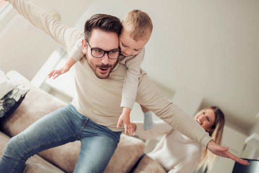 Haus-Familie-Wohnen-Serie-27-6 Vater mit Kind auf Rücken